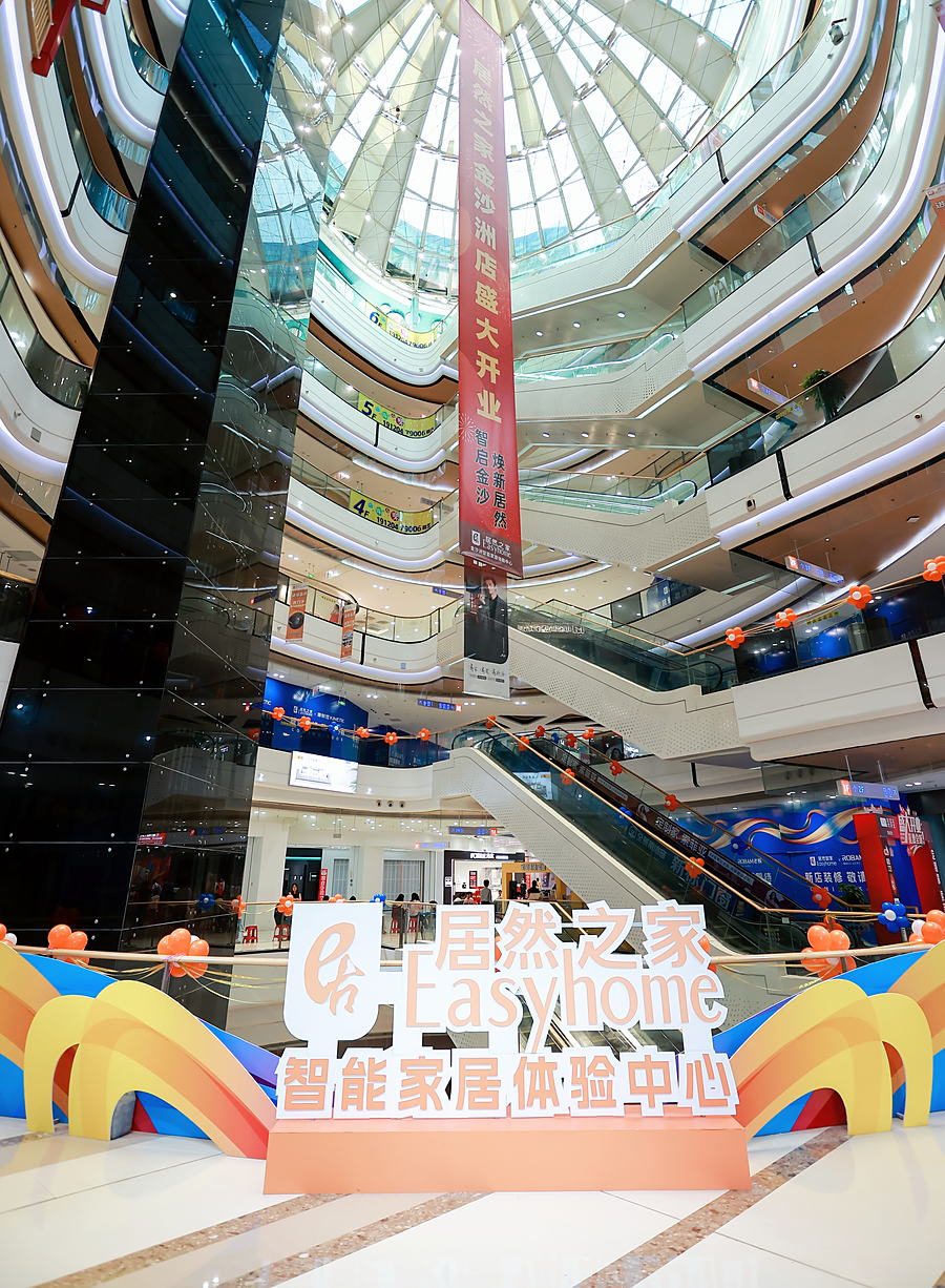 Six-storey atrium inside the Easyhome Foshan showroom, with escalators and glass balustrades.